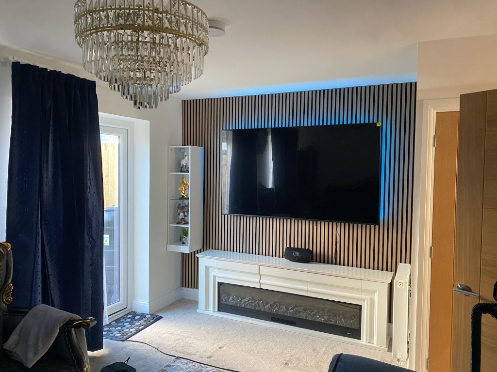 Finished oak slat media wall with wall-mounted TV and fireplace